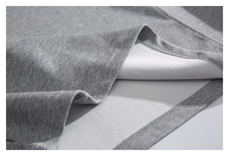 Inside view showing the overlocked stitching along the hem of a heather gray sweatshirt.