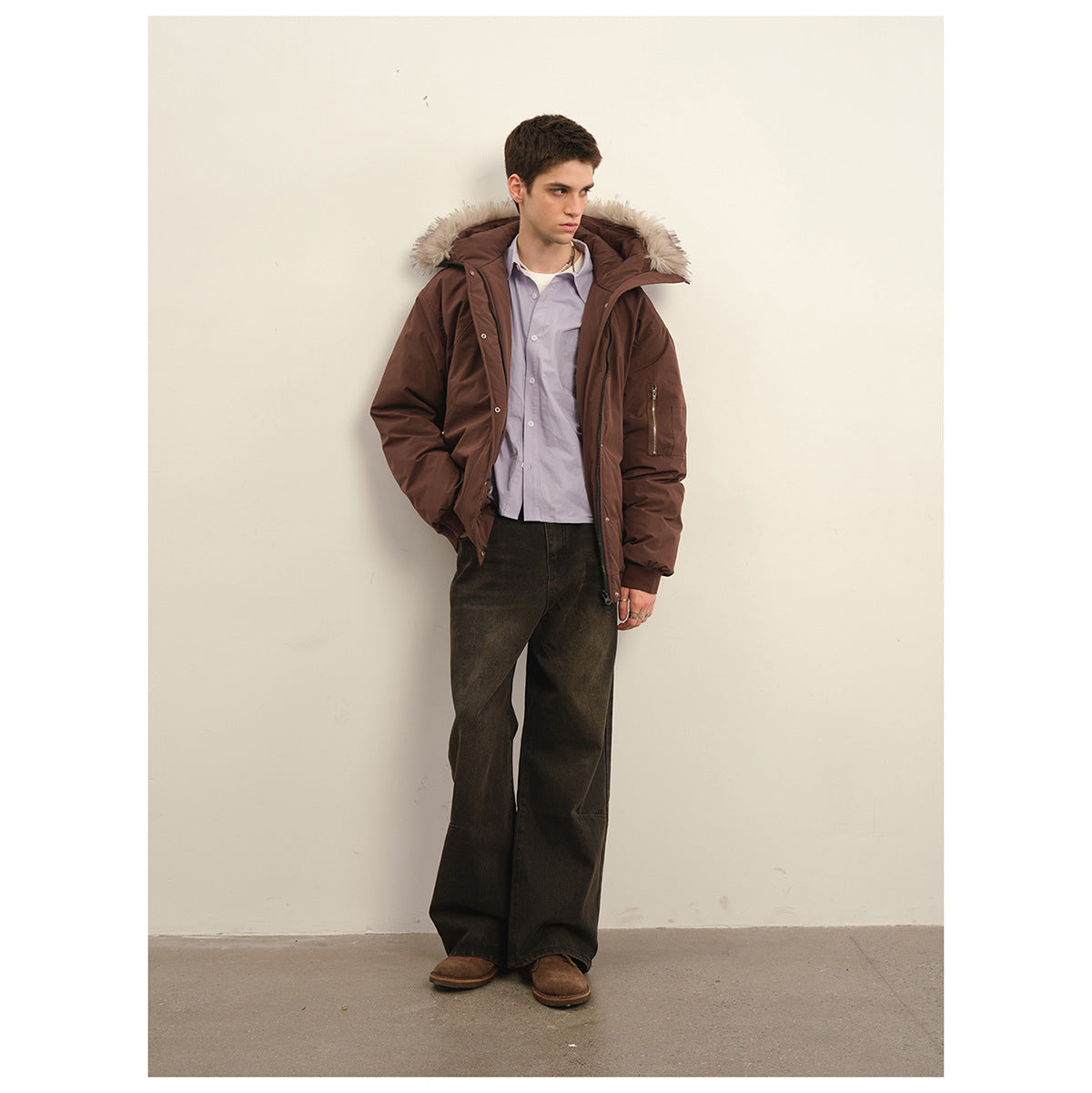 Man wearing an open dark brown fur-trimmed hooded jacket over a light shirt, front view.