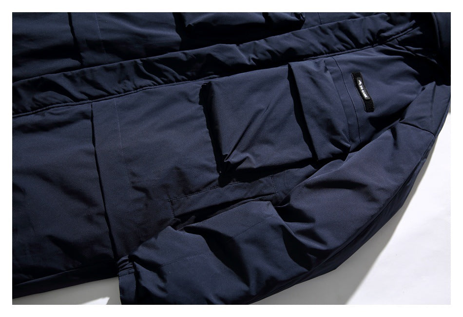 Dark navy jacket laid flat, showing its sleeve, seams, and large flap pocket.