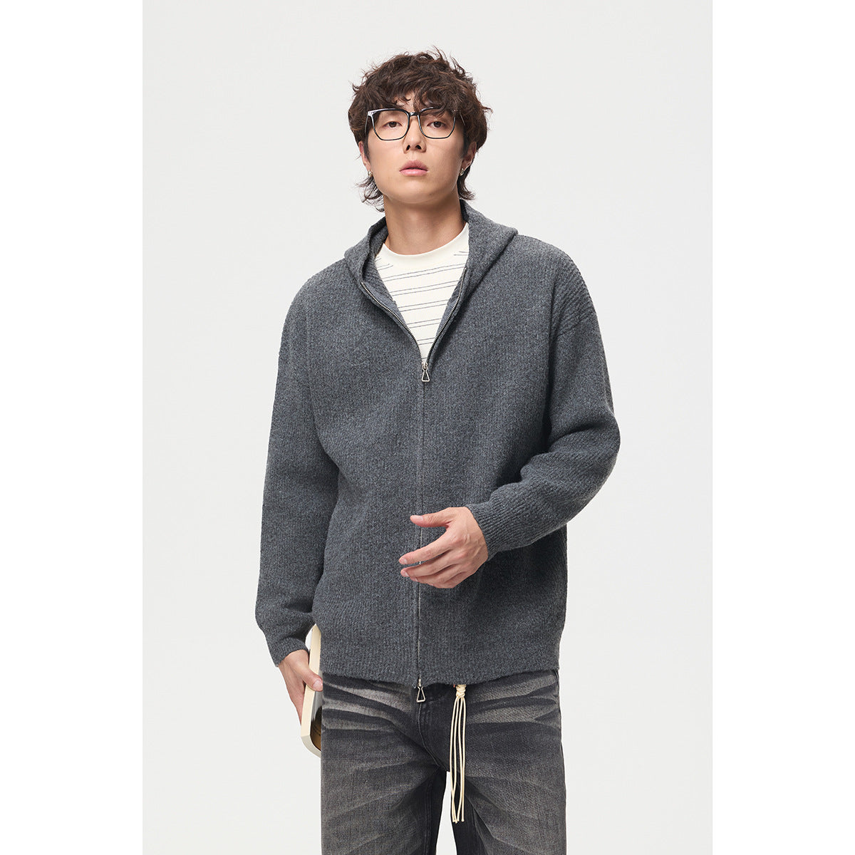 Model wearing a charcoal gray zip-front hooded sweater over a striped shirt, shown from the front.