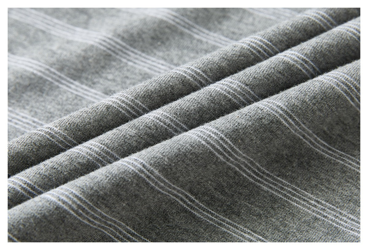 Close-up of gray fabric with fine light stripes, folded to show its surface and drape.
