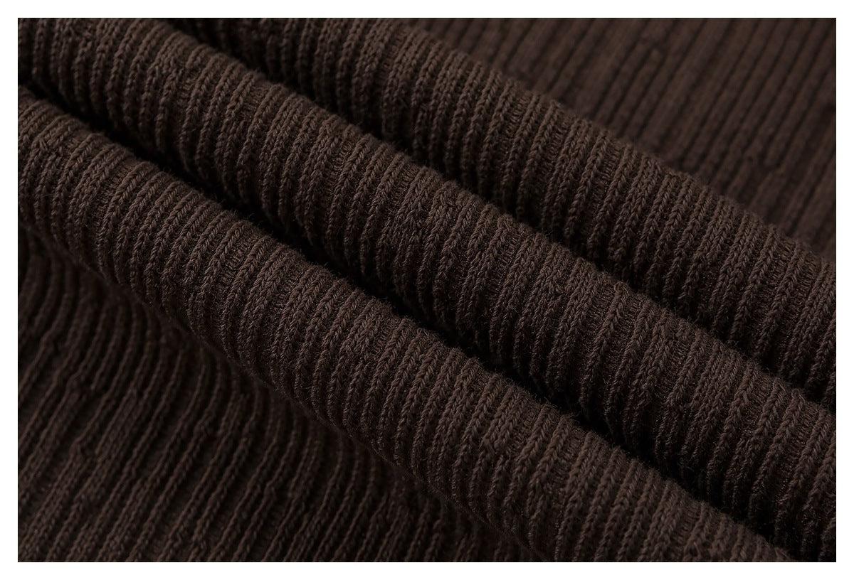Macro view of the brown garment's raised ribbed texture and folded fabric.