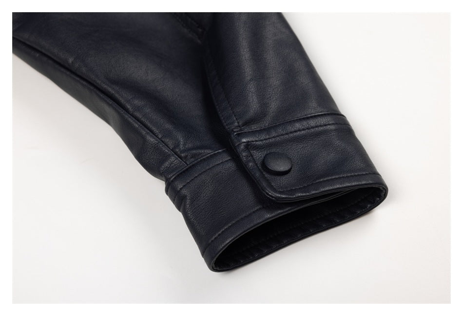Close-up of a black jacket sleeve cuff with a snap-button tab and visible stitching.
