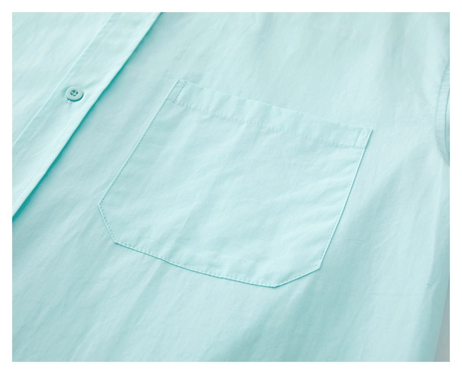 Close-up of the aqua shirt's single front patch pocket and nearby placket button.