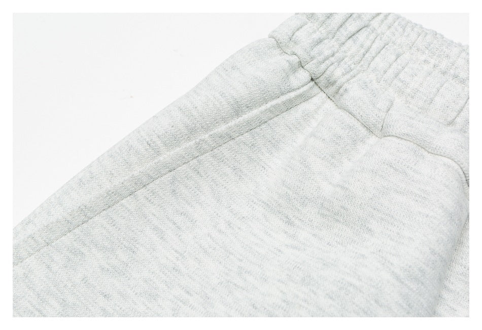 Close-up of gray pants showing the elastic waistband and upper seam details.