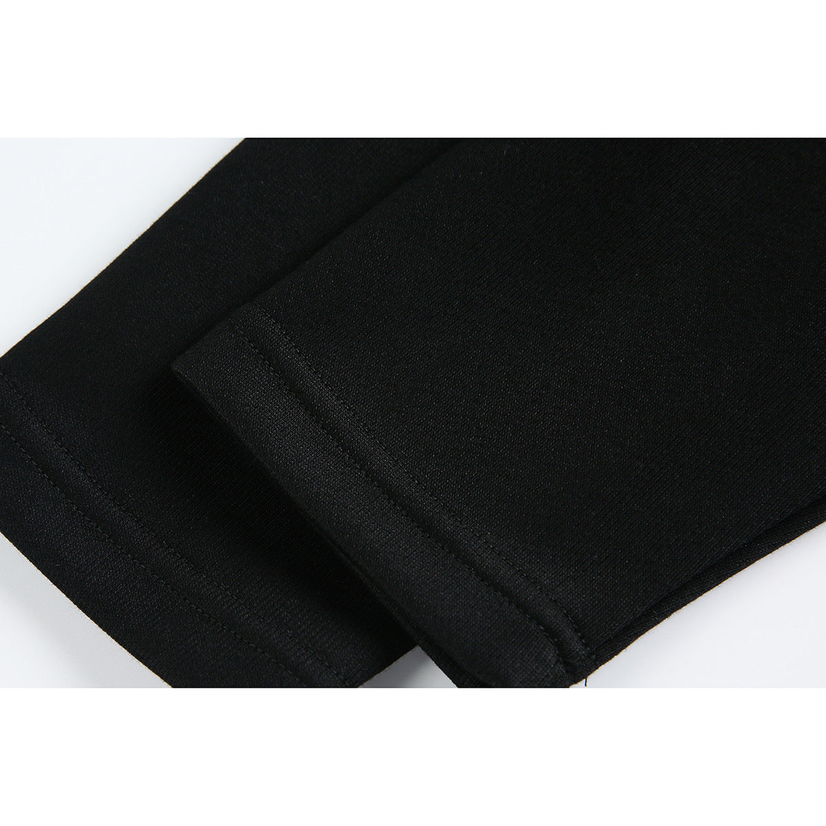 Close-up of black garment fabric and a stitched edge seam.