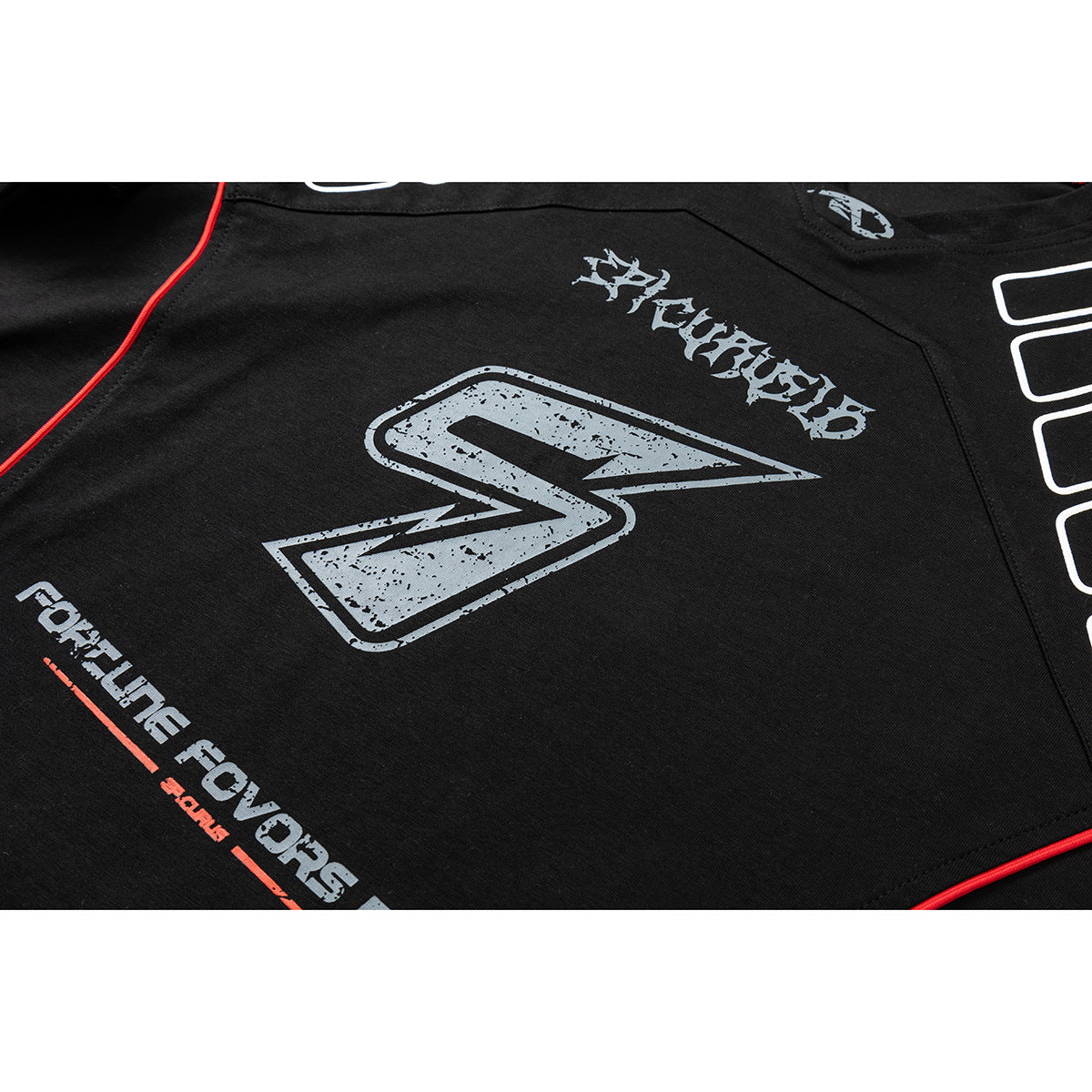 Close-up of a black shirt with a distressed gray graphic, stylized lettering, and red piping.