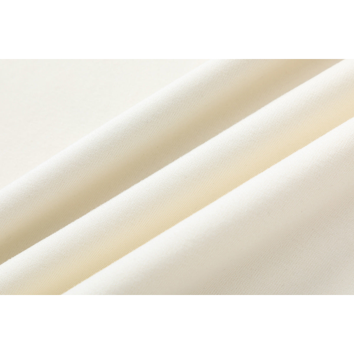 Close-up of the smooth, off-white sweatshirt fabric arranged in soft folds.