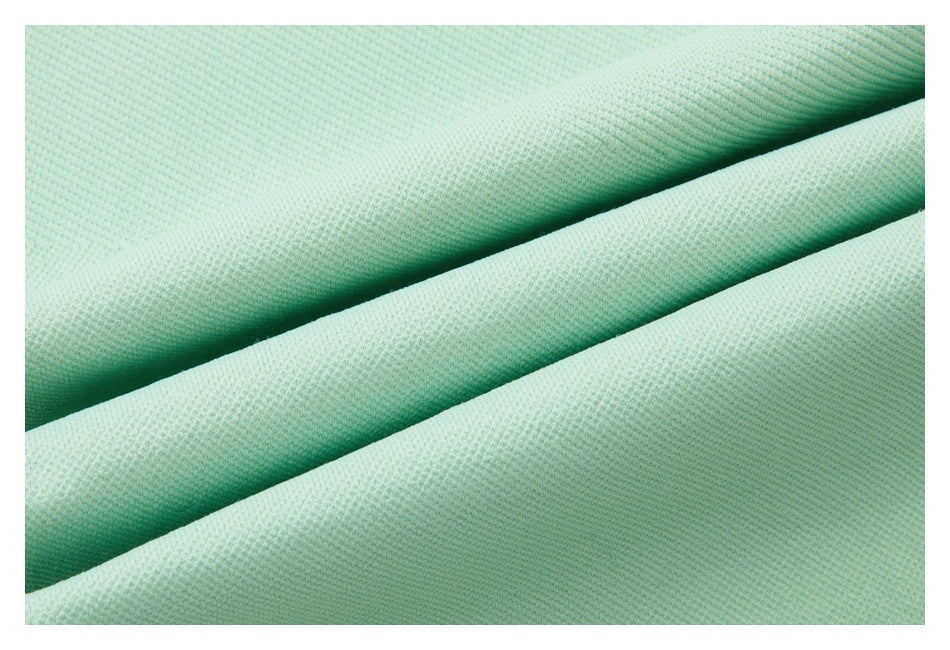 Close-up of mint-green fabric folded to show its fine textured surface.