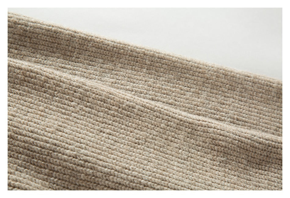 Close-up showing the beige sweater's textured rib-knit fabric.