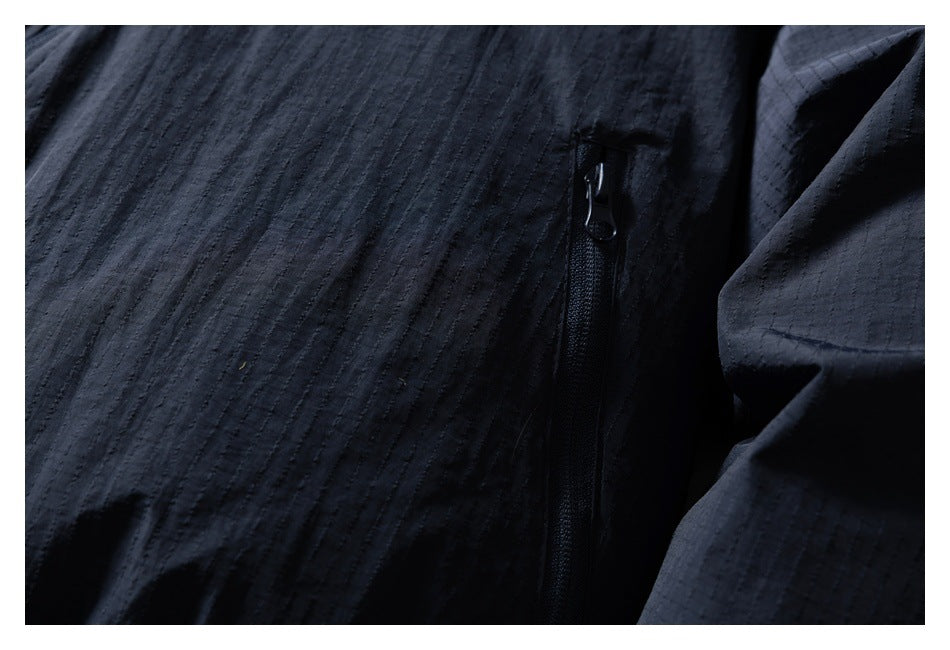 Close-up of a vertical zip pocket on the dark navy jacket.