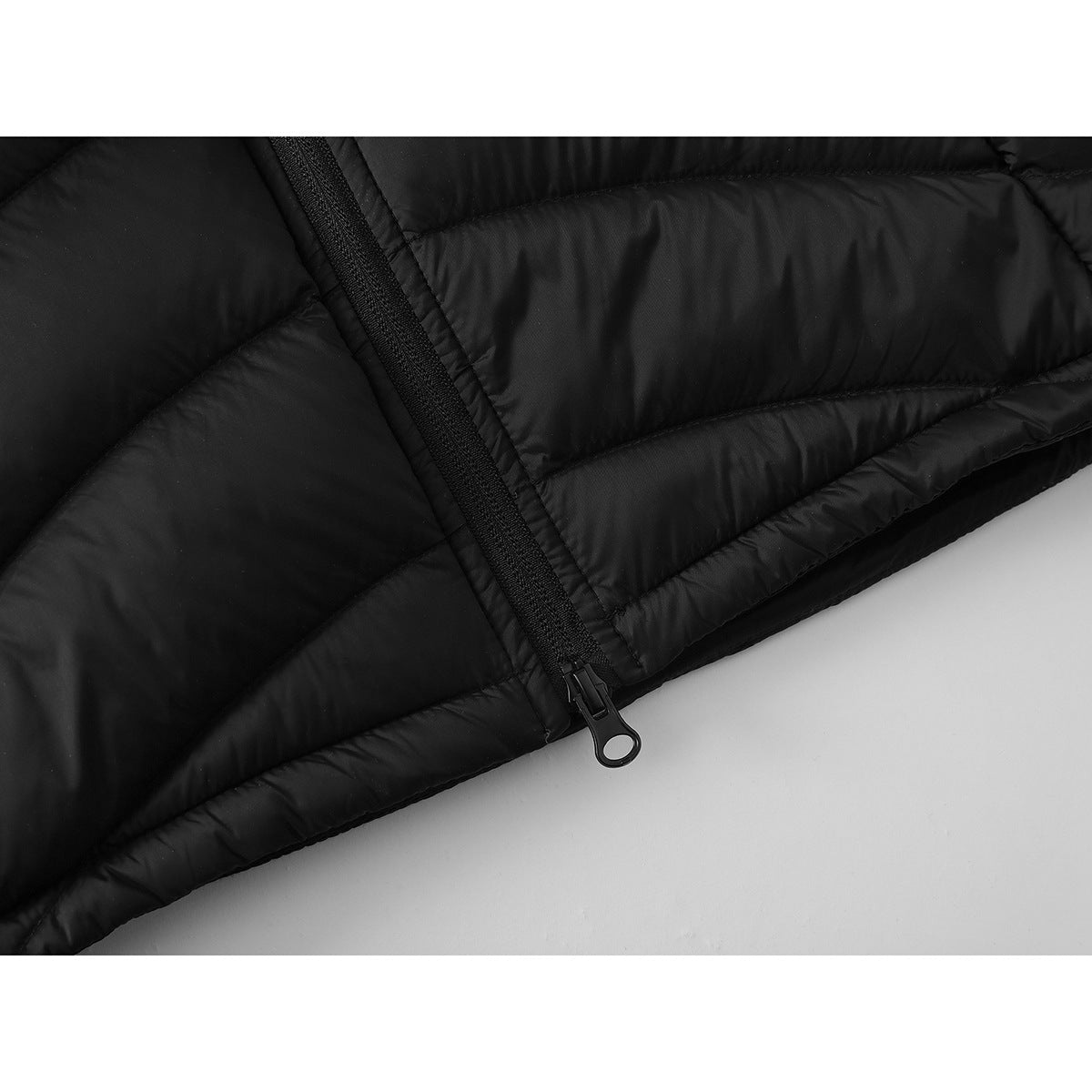Close-up of the black vest's front zipper and quilted hem.