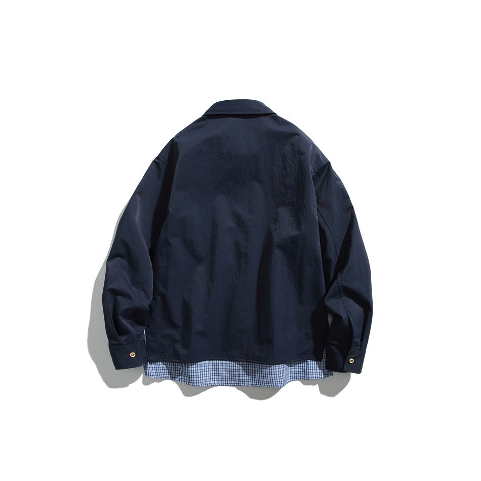 Back view of a navy button-up shirt with blue plaid fabric visible below the hem.