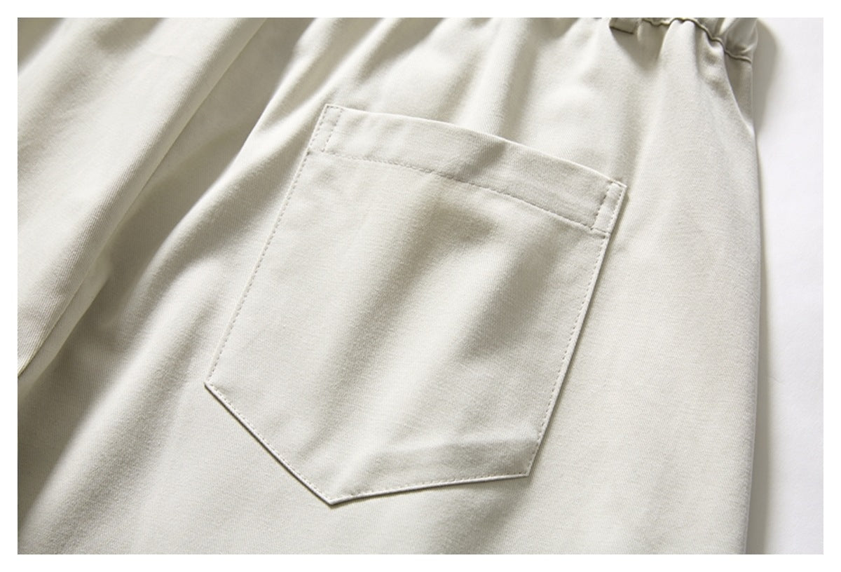 Close-up of a large angular patch pocket on cream trousers.