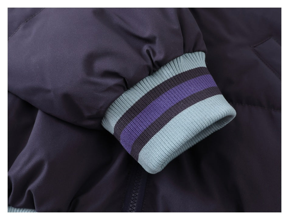Close-up of a dark navy jacket sleeve ending in a light blue ribbed cuff with purple and dark stripes.