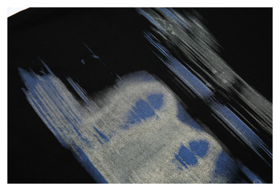 Close-up of a blue and gray brushstroke graphic printed on black fabric.