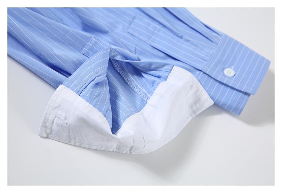 Close-up of a light blue pinstriped shirt cuff and sleeve with white inner fabric exposed.