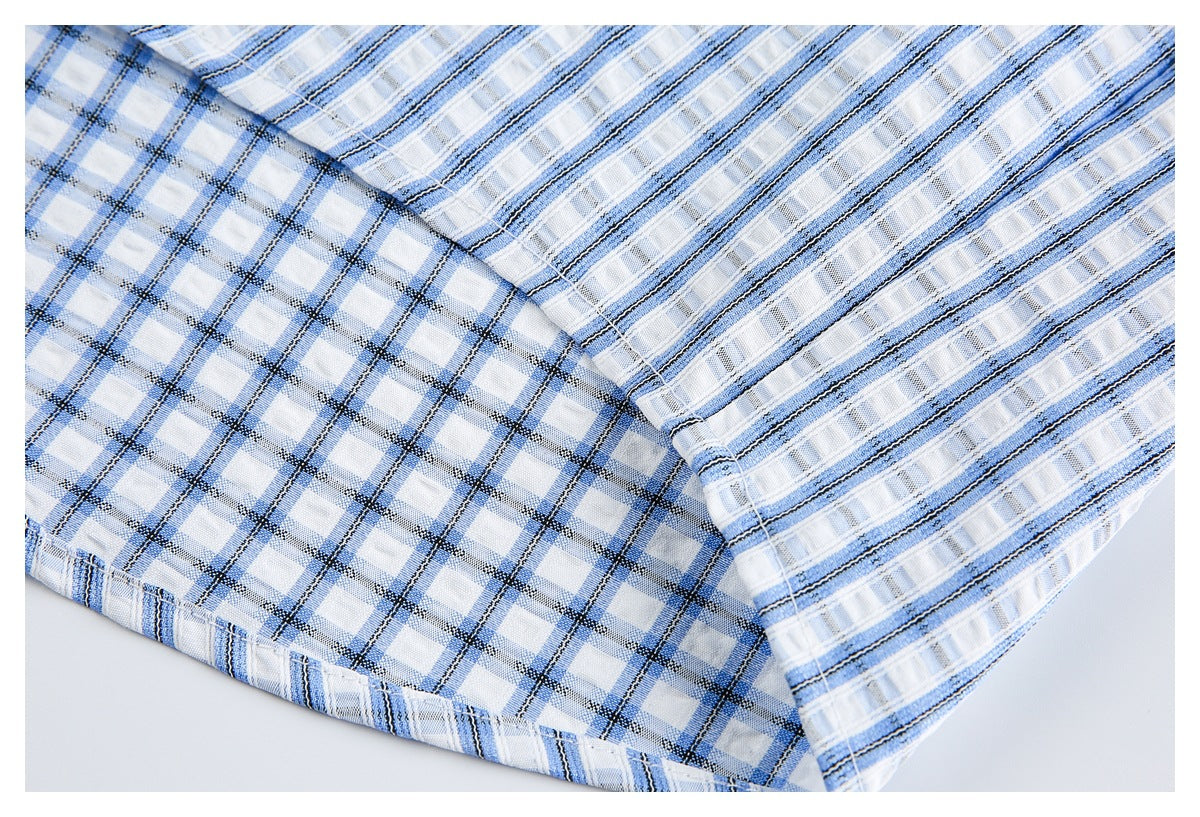 Close-up showing the blue-and-white striped shirt fabric beside a contrasting checked panel and stitched seam.