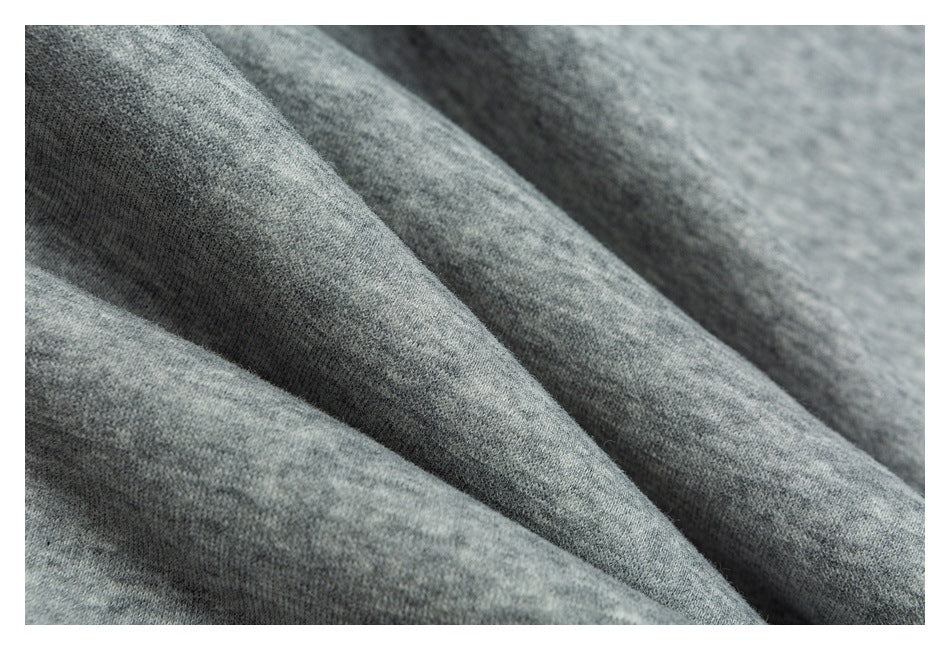 Extreme close-up of folds in gray heathered garment fabric.