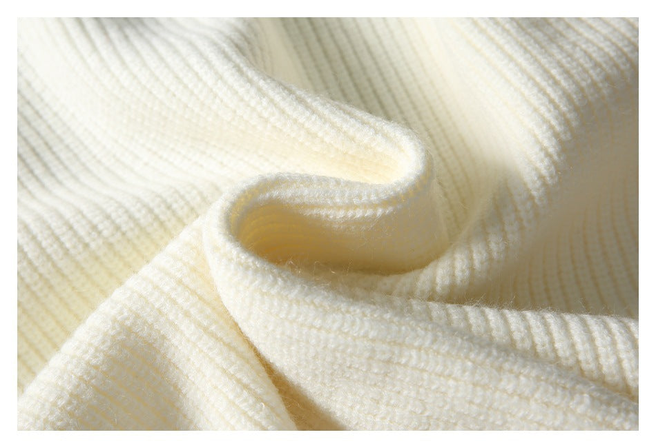 Close-up of ivory rib-knit fabric gathered to show its texture and soft folded edge.