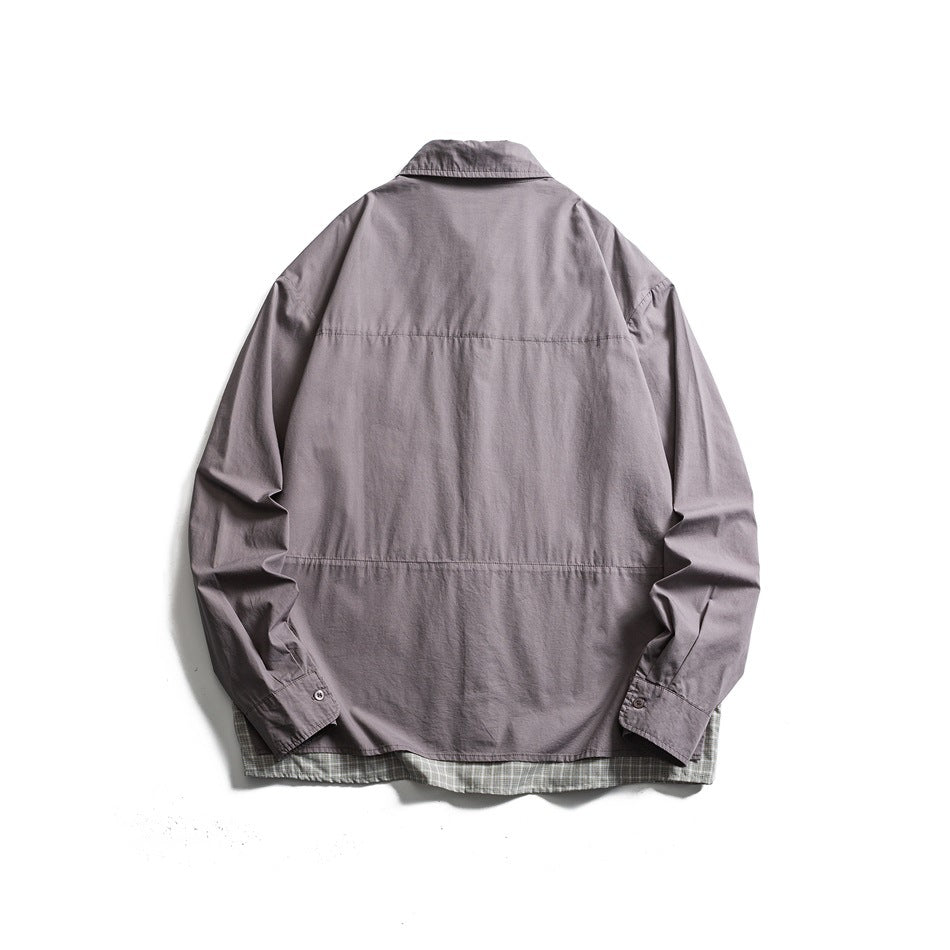 Back view of a gray long-sleeve button-up shirt with a pointed collar and plaid fabric peeking below the hem.