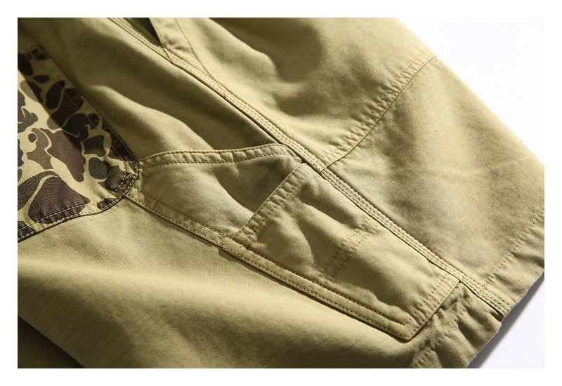 Close-up of a khaki garment showing a rectangular stitched pocket and camouflage-print panel.