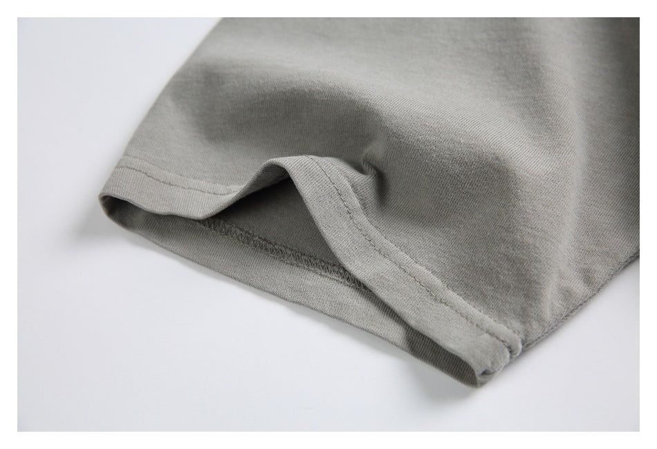 Close-up of a gray T-shirt sleeve hem showing the folded edge and stitching.