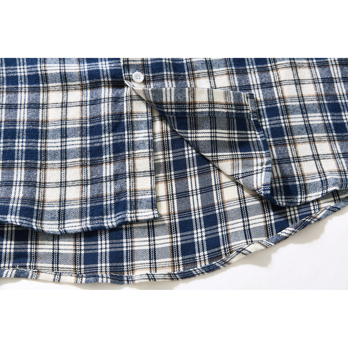 Close-up of a navy and cream plaid shirt showing a button and a folded pocket area near the curved hem.