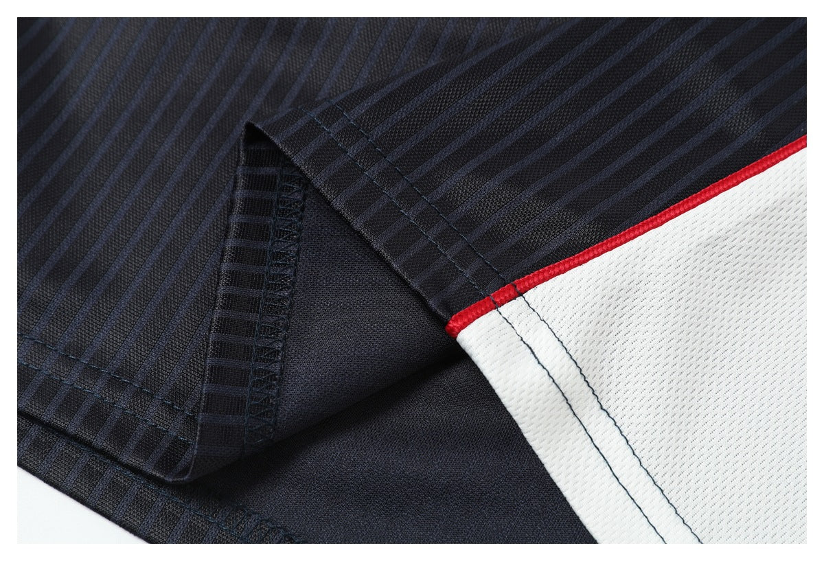 Close-up of jersey stitching and a white side panel with narrow red piping.