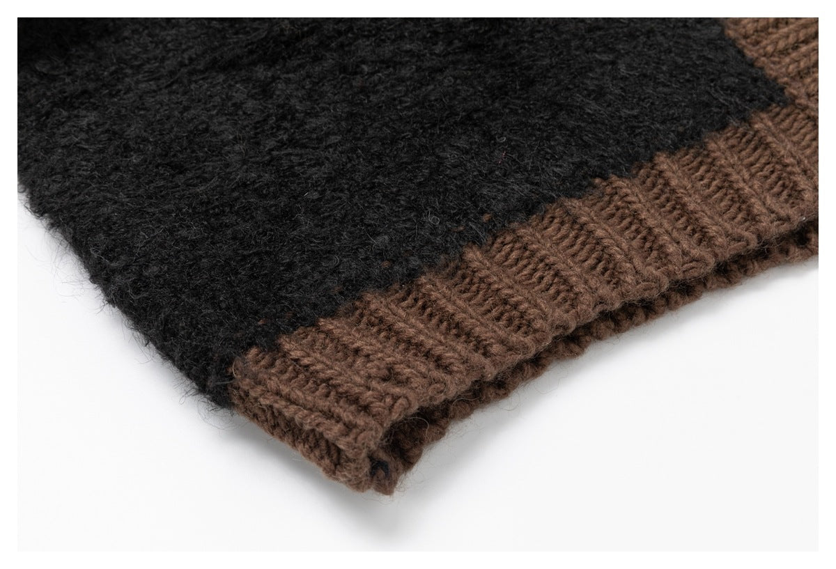 Close-up of the cardigan’s brown ribbed hem beside its fuzzy black knit body.