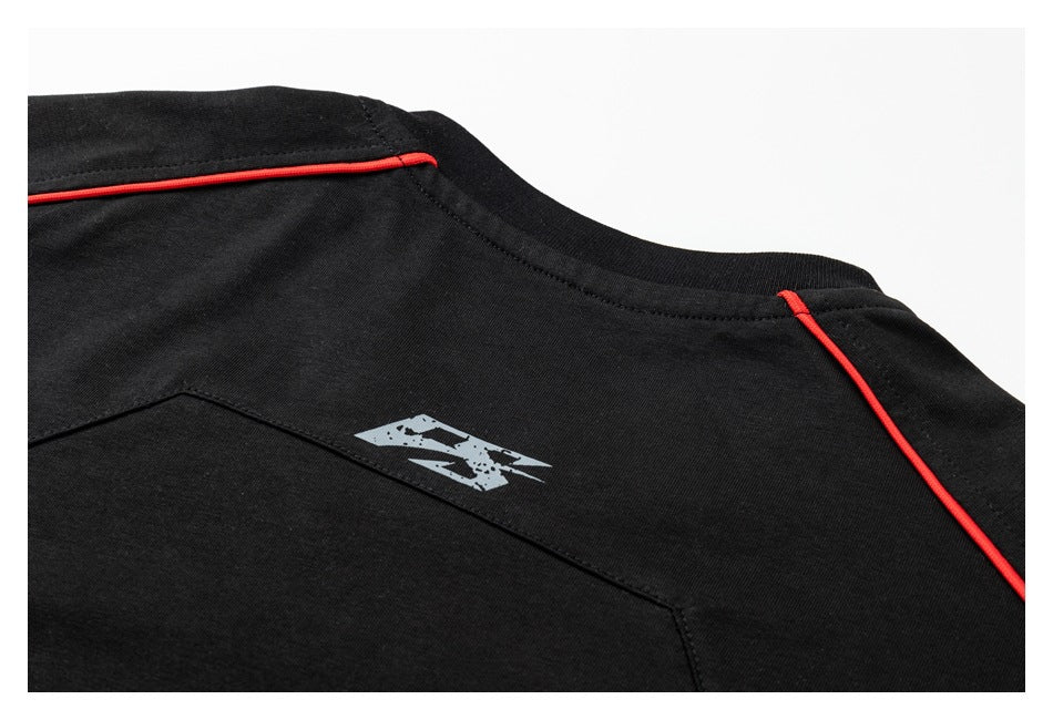 Close-up of the back of a black shirt with red piping and a small distressed gray graphic.