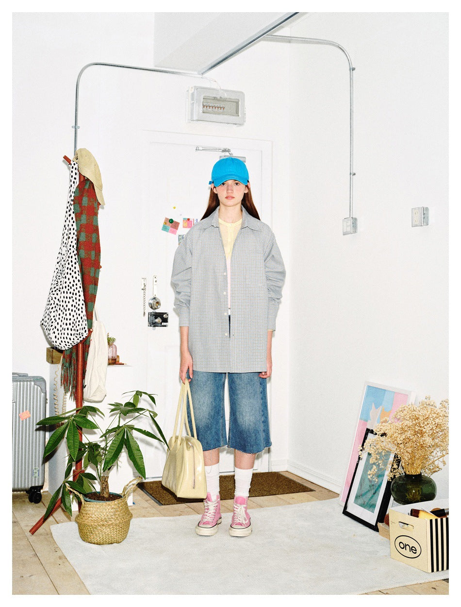 Model wearing the light blue check shirt open over a tee with denim shorts, blue cap and pink sneakers
