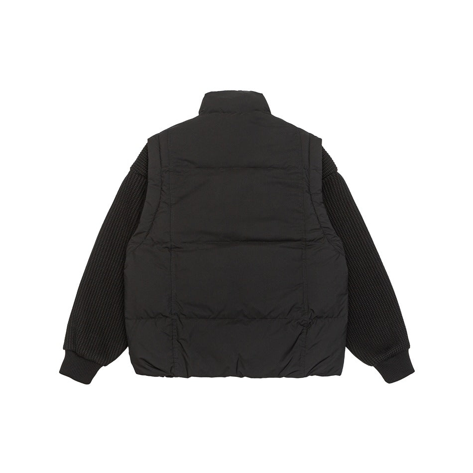 Back view of a black jacket with a padded body, textured knit sleeves, high collar and ribbed cuffs.