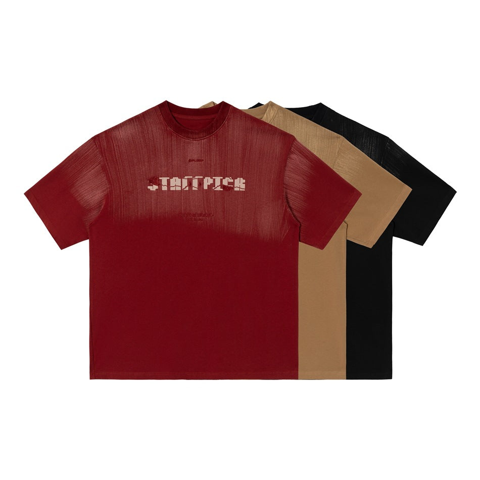 Three overlapping short-sleeve crew-neck T-shirts in red, tan, and black, shown from the front.