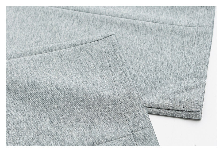 Close-up of heather gray shorts showing a slanted pocket opening and stitched hem.