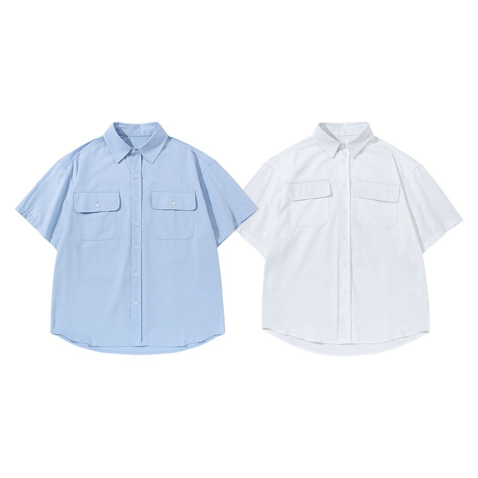 Front view of two short-sleeve button-up shirts with chest pockets, one light blue and one white.