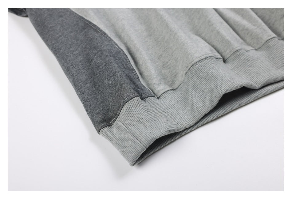 Close-up of a gray sweatshirt's ribbed hem and dark gray side panel.