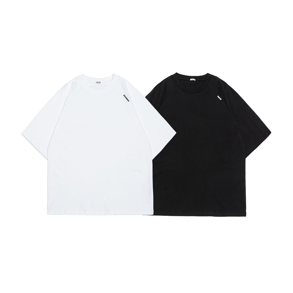 White and black short-sleeve crew-neck T-shirts shown from the front, each with a small chest mark.