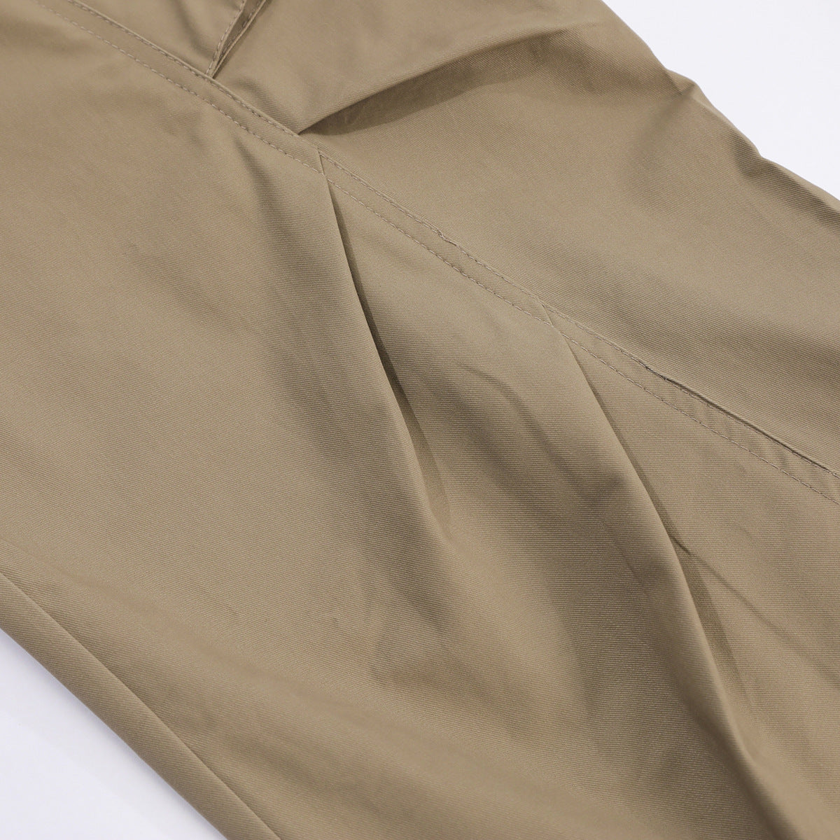 Close-up of tan cargo pants showing stitched seams and smooth fabric.