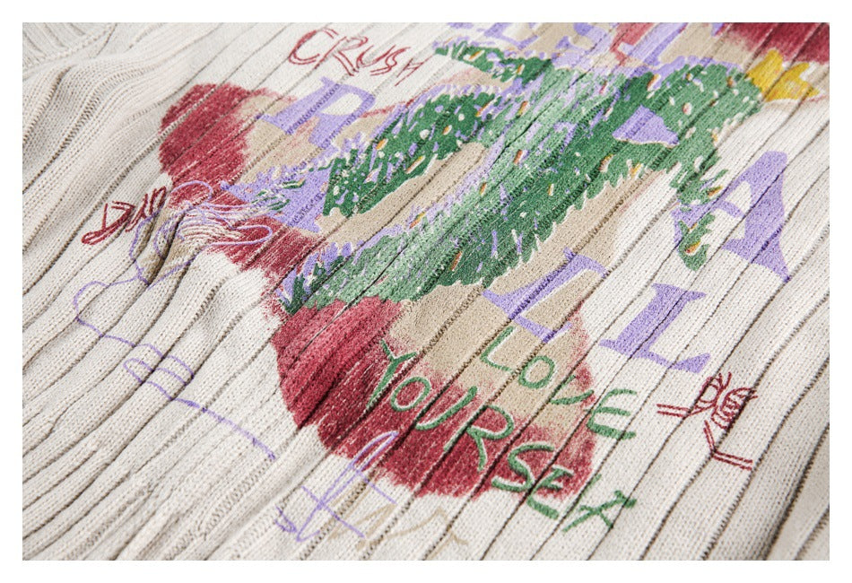 Close-up of a cream rib-knit garment with colorful abstract graphics and English lettering.