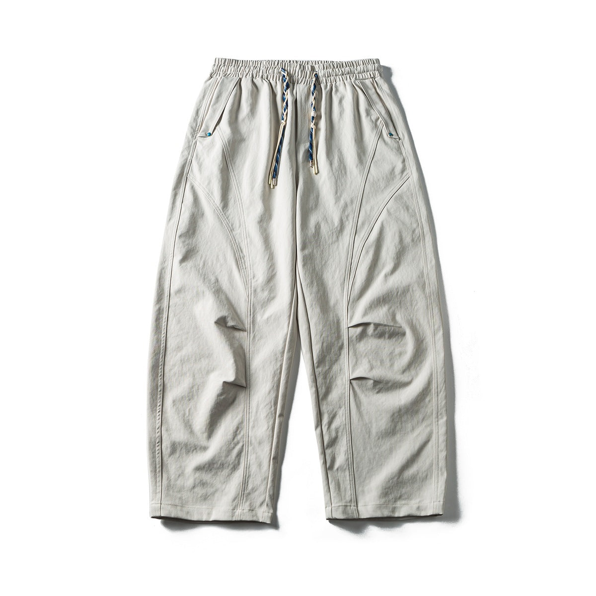 Off-white wide-leg pants flat lay with blue braided drawstring, curved seams and knee pleats