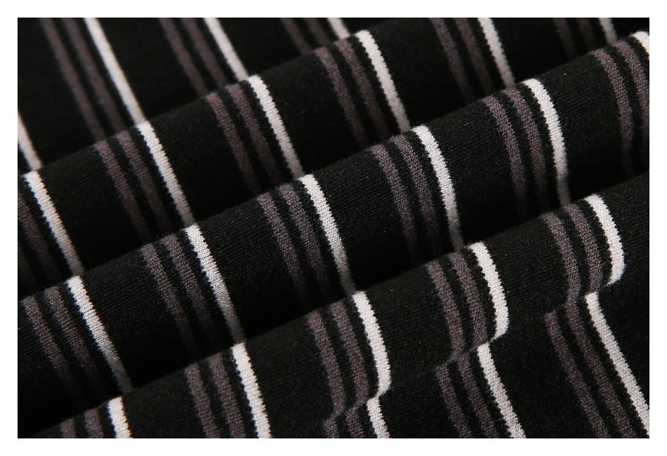Close-up of black knit fabric with narrow white and muted gray horizontal stripes.