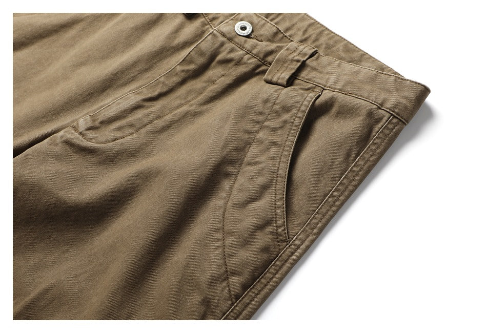 Close-up of the khaki-brown pants' front pocket, waistband, belt loop, and metal button.