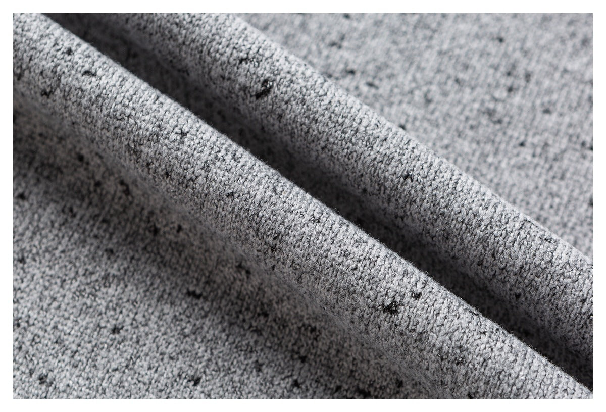 Macro view of gray flecked knit fabric draped to show its texture.
