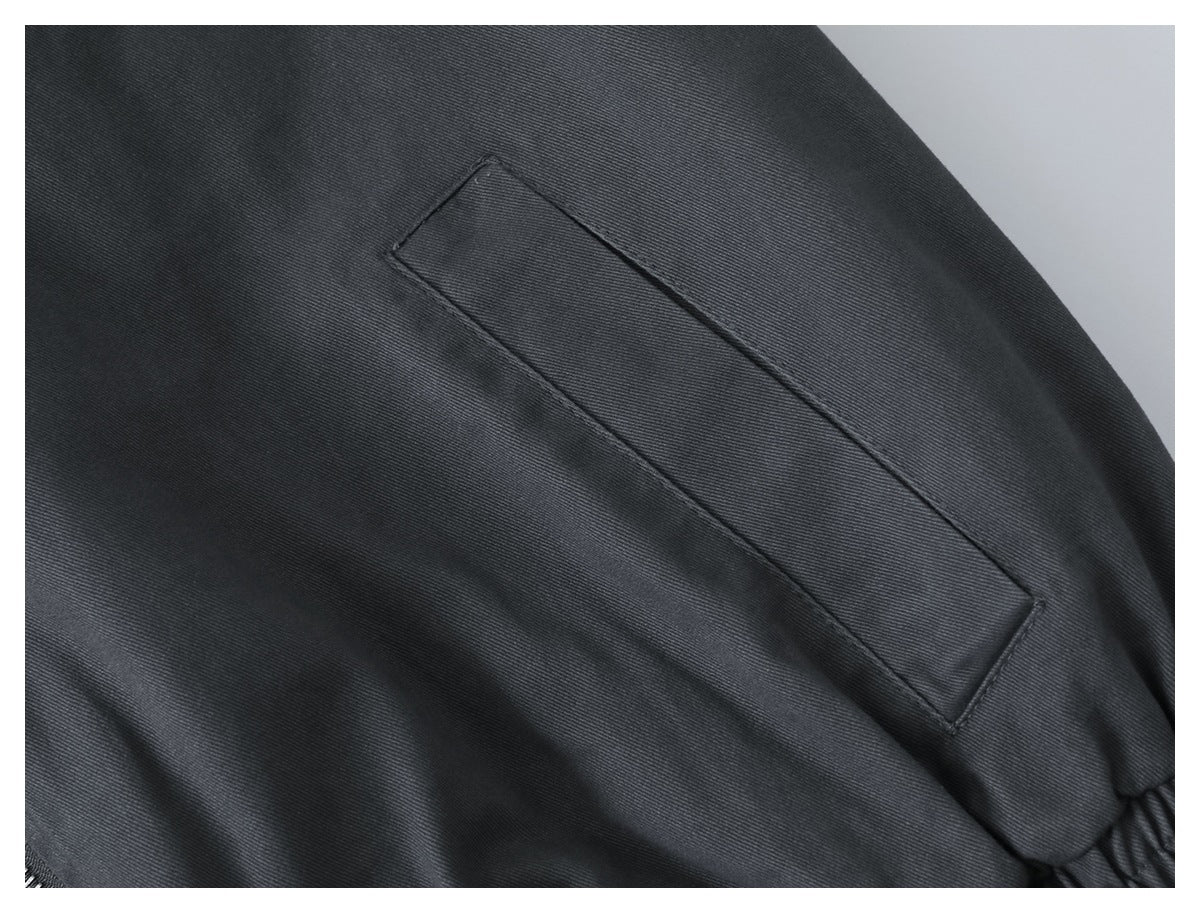 Close-up of a slanted welt pocket on the charcoal jacket.
