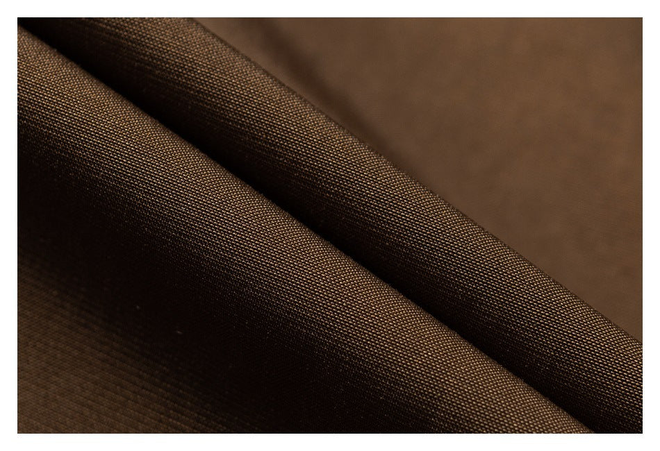 Close-up of brown garment fabric showing its fine woven texture and folds.