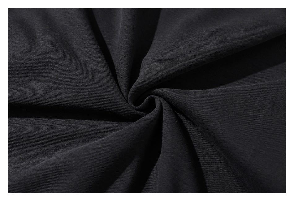 Close-up of black fabric gathered into a spiral, showing its fine woven texture.