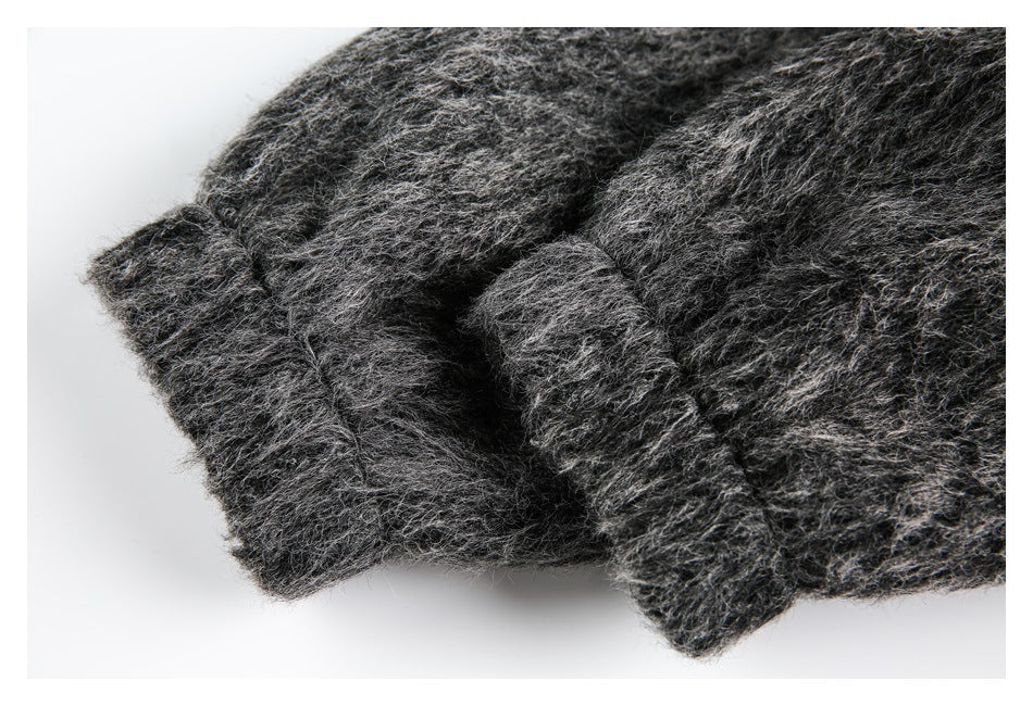 Close-up of a folded edge and seam in shaggy charcoal-gray fabric.