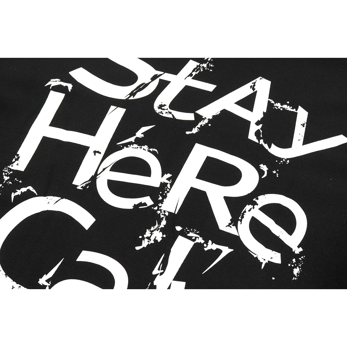 Close-up of distressed white lettering printed on black shirt fabric.