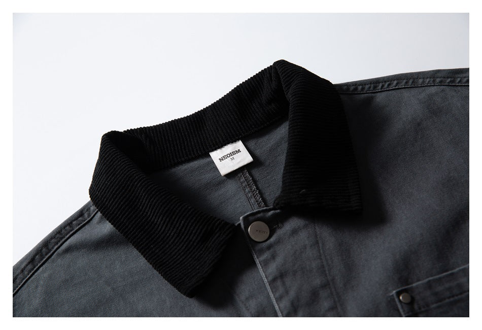 Close-up of a charcoal jacket collar with a black ribbed collar, dark button, and small neck label.